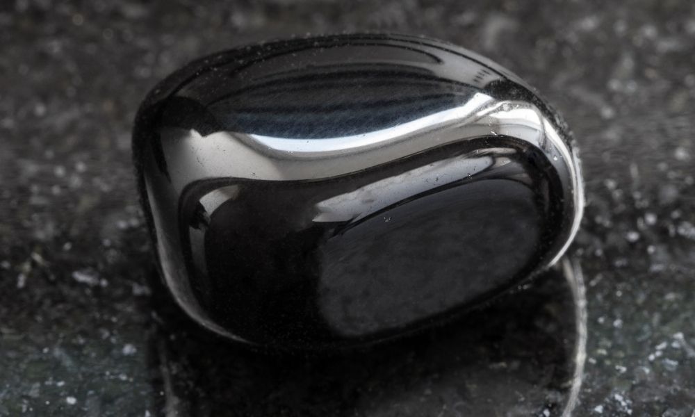 a black shiny stone on a black surface