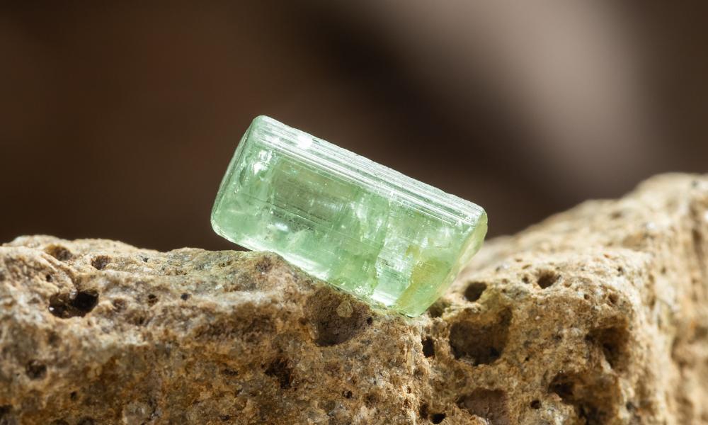 a green tourmaline on a rock