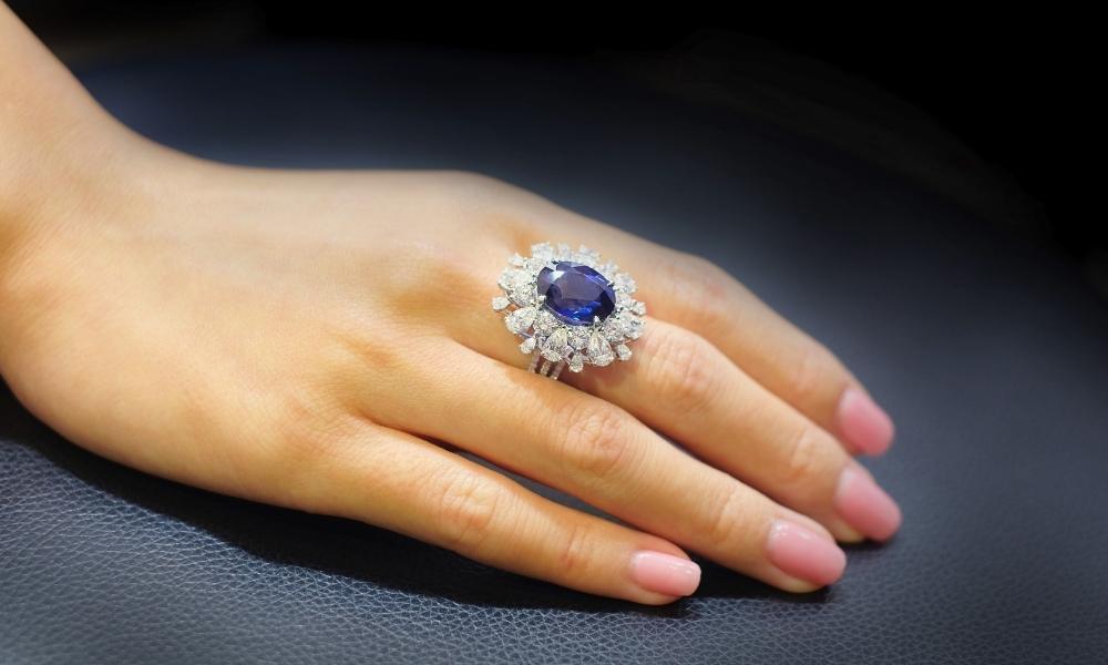 a hand with a ceylon sapphire ring on it