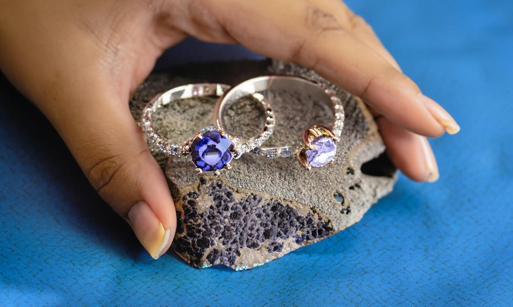 a hand holding a pair of montana sapphire rings