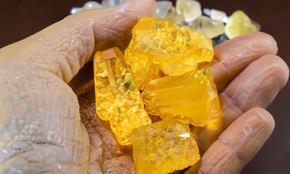 a person holding a group of yellow crystals