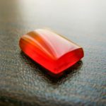 red agate, on a grain-brown surface.