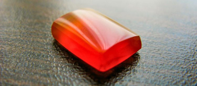 red agate, on a grain-brown surface.