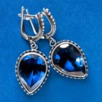 a blue background with blue sapphire earrings