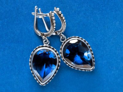 a blue background with blue sapphire earrings
