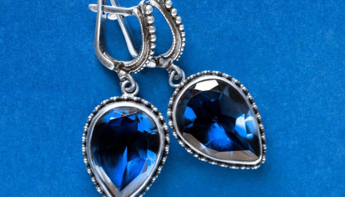 a blue background with blue sapphire earrings