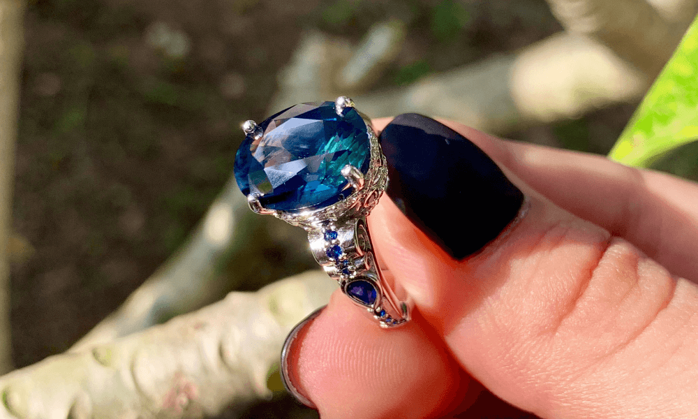 a woman's hand holding a vintage sapphire ring