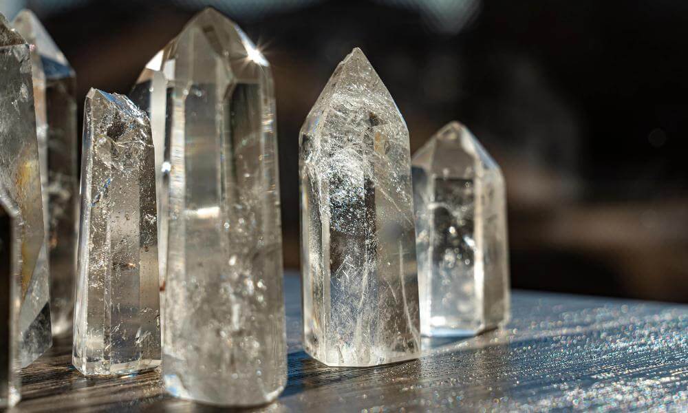 a group of rock crystal clear quartz sitting on top of a wooden table
