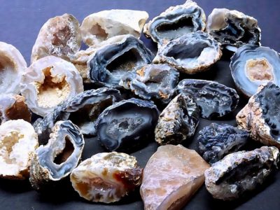 different colors and different sizes of druzy agate on a purple surface