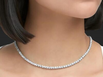 a close-up of a diamond tennis necklace on a mannequin's neck with short hair.