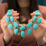 a girl holding a beautiful turquoise necklace