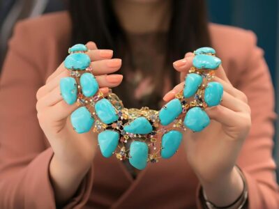 a girl holding a beautiful turquoise necklace