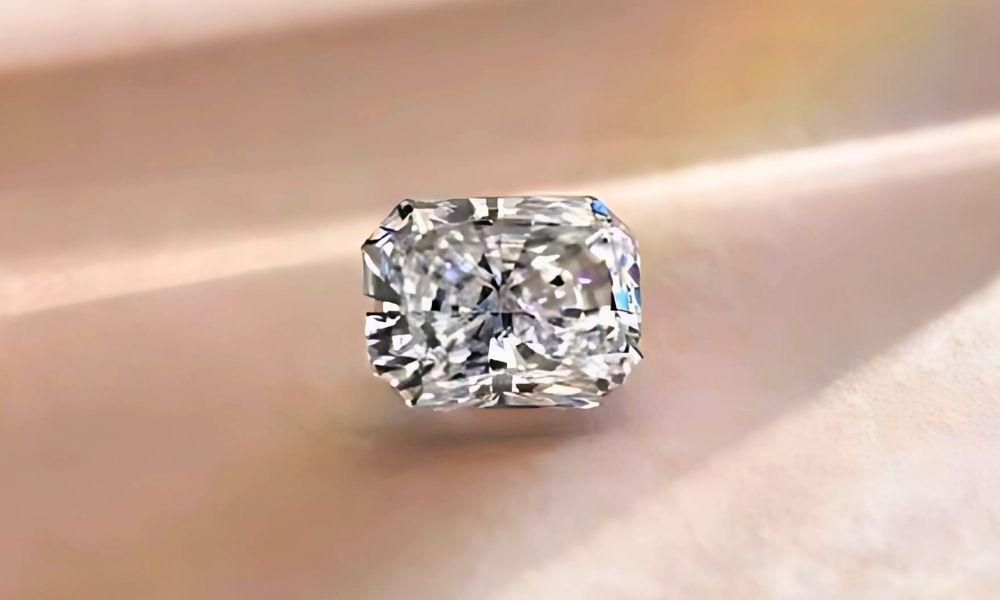 A sparkling radiant cut diamond on a soft, blurred background.