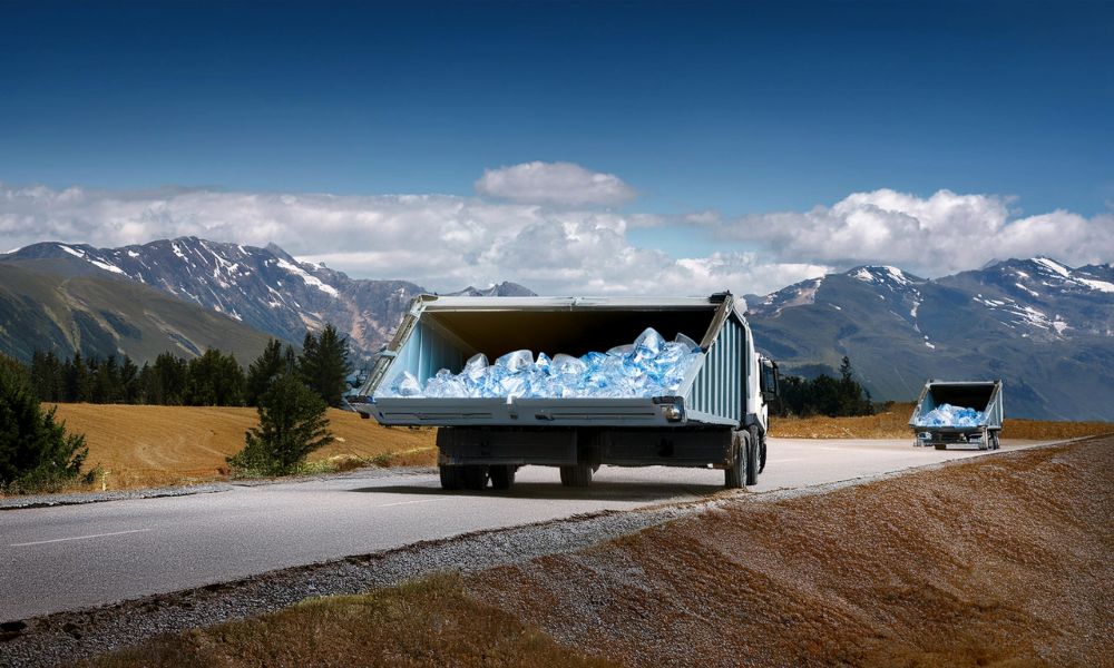 A truck and a smaller vehicle carrying oversized clear plastic bags on a mountain road.