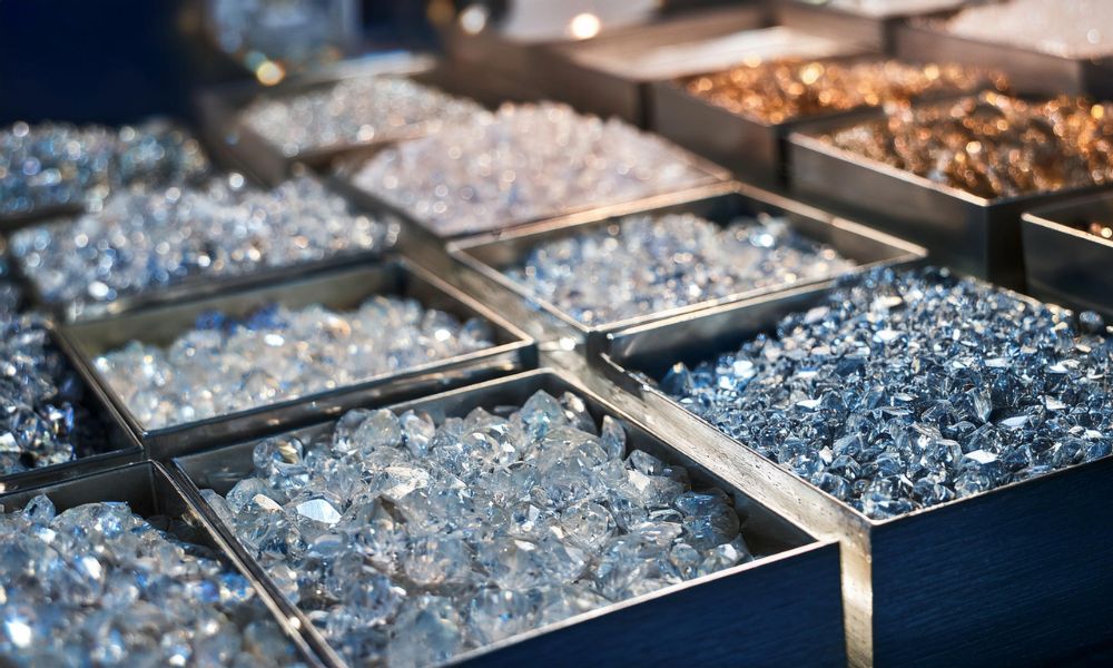 Trays of sparkling loose diamond stones in varying shades, displayed in a well-lit setting.