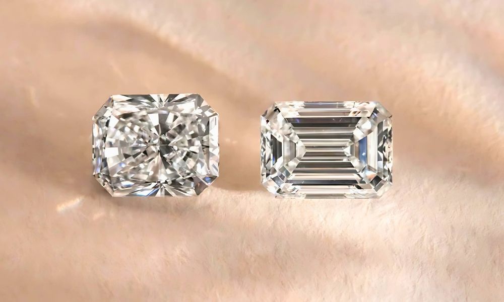 A sparkling radiant and emerald cut diamonds on a soft surface.