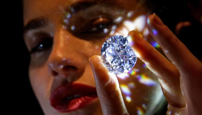 A girl has taken the diamond in her hand. The purpose of showing this picture is why are diamonds so expensive.