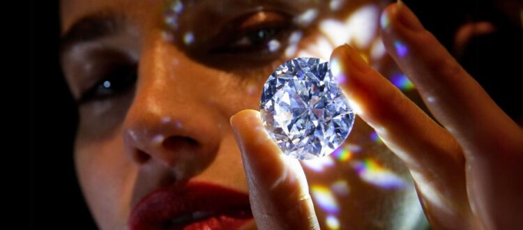 A girl has taken the diamond in her hand. The purpose of showing this picture is why are diamonds so expensive.